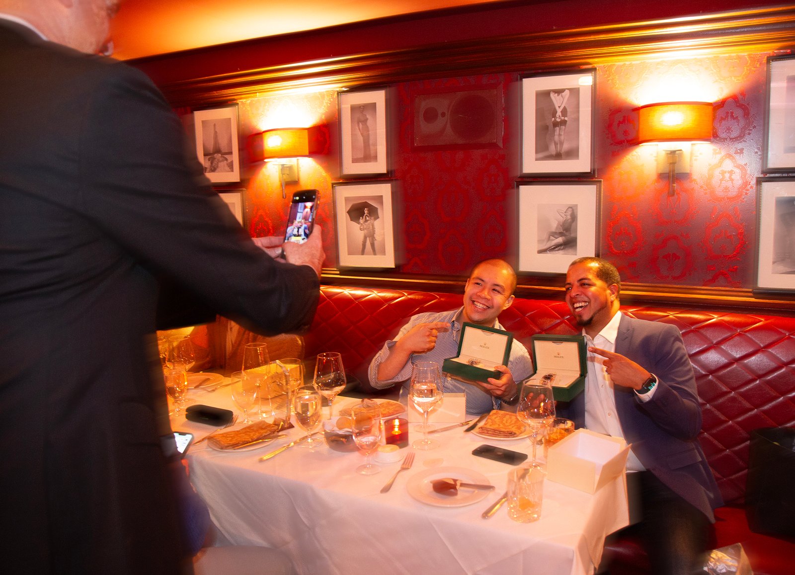 two successful sales team members pose for Frank who take phone pictures