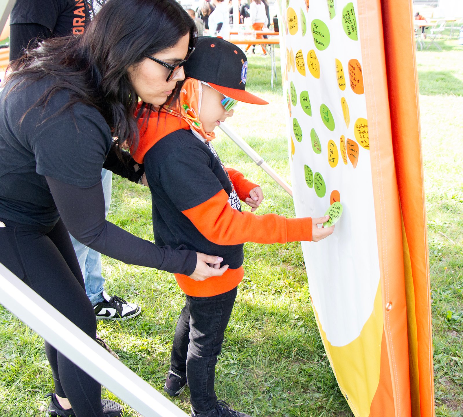 woman and child add a handwritten circle to a wall
