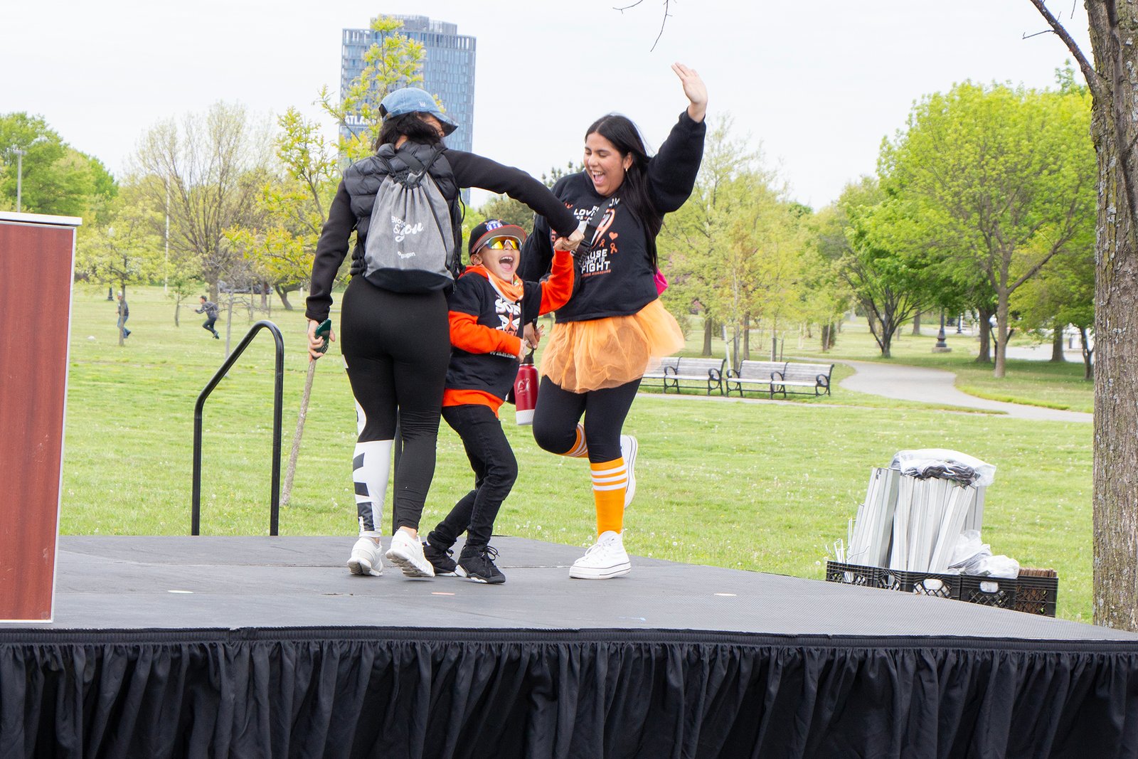 two women and a boy dance on a stage after finishing the walk