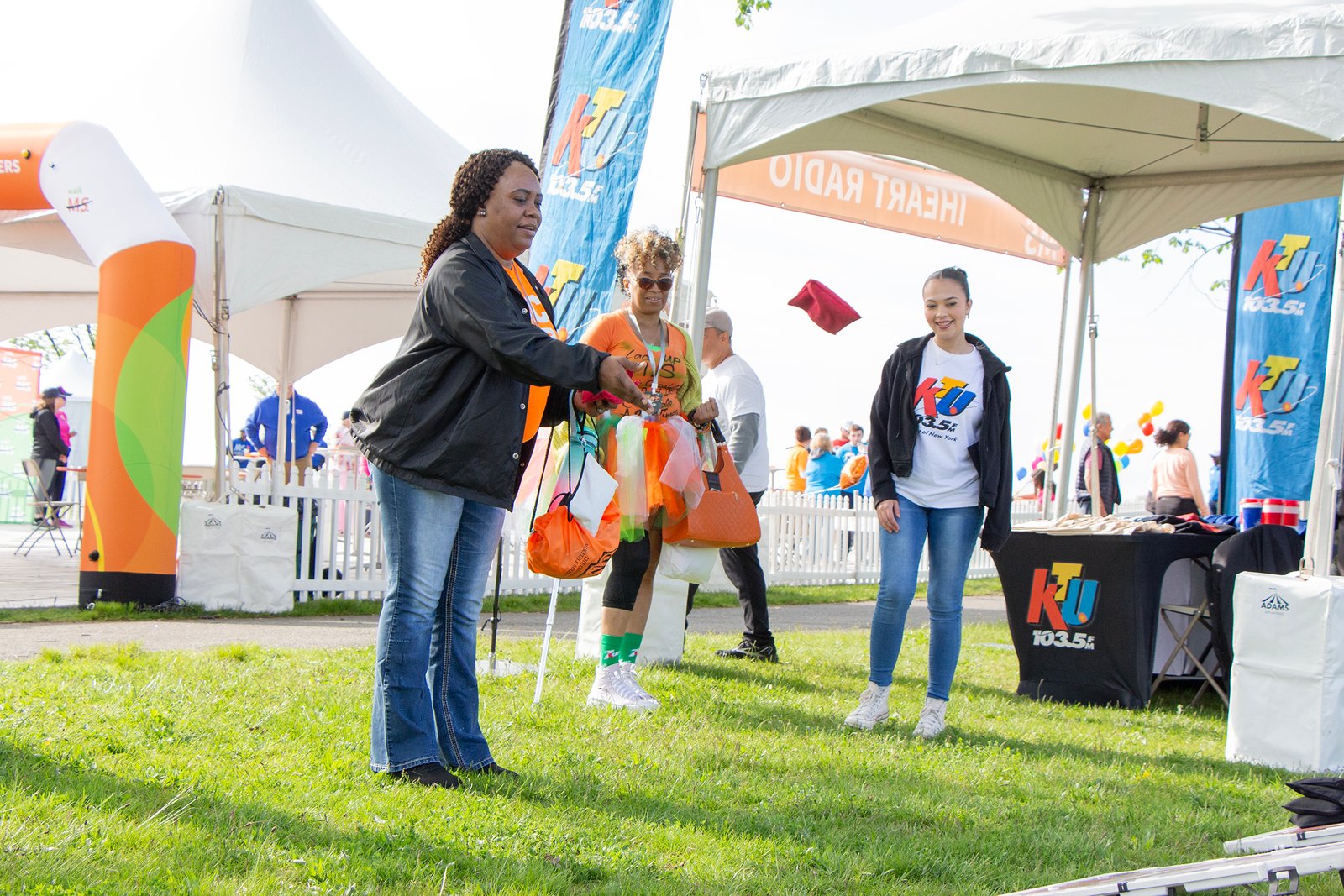 two participants play cornhole at the KTU sponsor tent