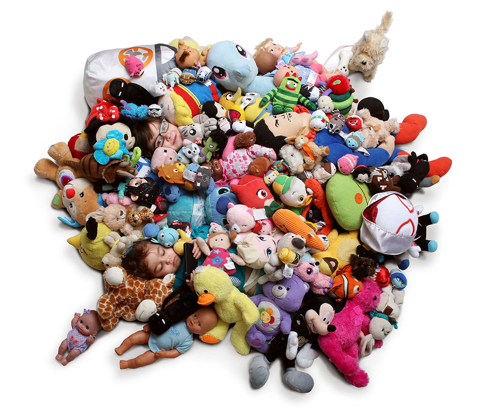 kids hiding in pile of stuffed animals