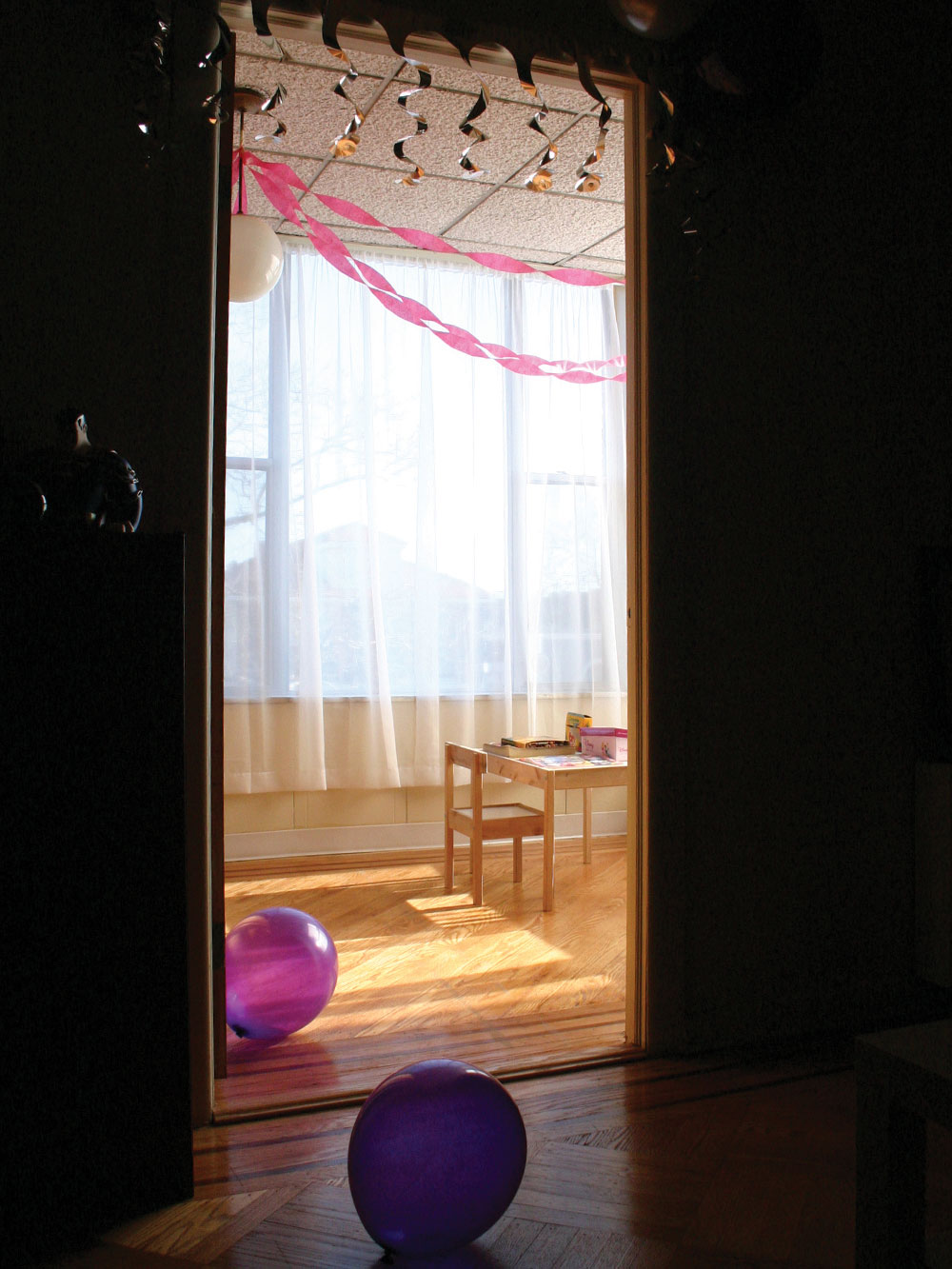 balloons and streamers in a sunlit room ready for a party